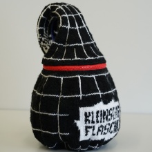 Eine Kleinsche Flasche, gestrickt in schwarzer und weißer Wolle mit rotem Reißverschluss
